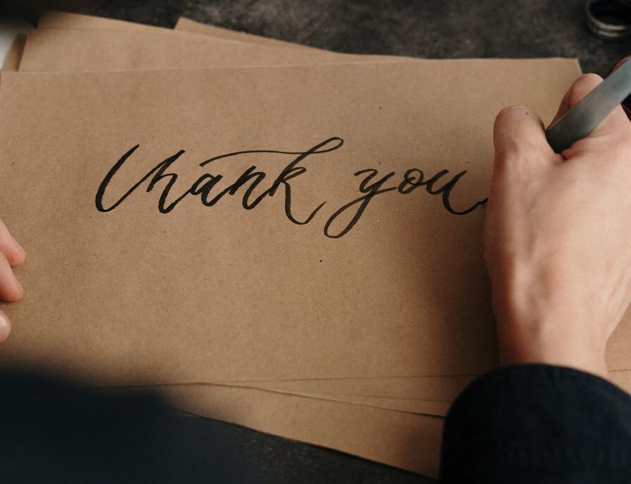 person writing on brown printer paper